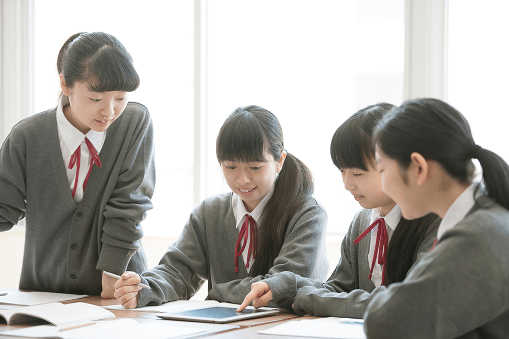 タブレットPCを使いグループ学習をする女子学生 脱『ティーチング』で協働学習を推進