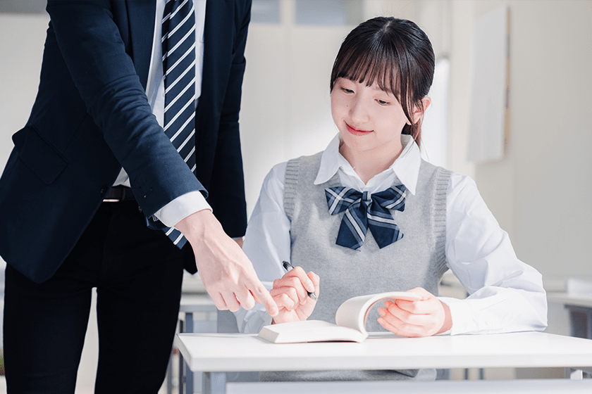 笑顔で授業をする女性教師 ティーチングの概念と教育