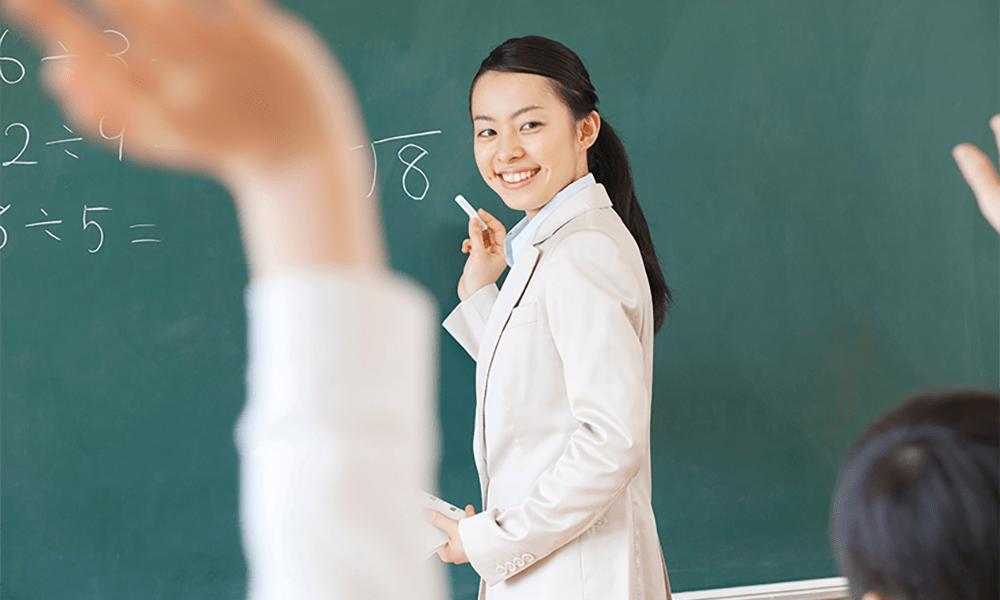 笑顔で授業をする女性教師 学校教育におけるティーチングの役割